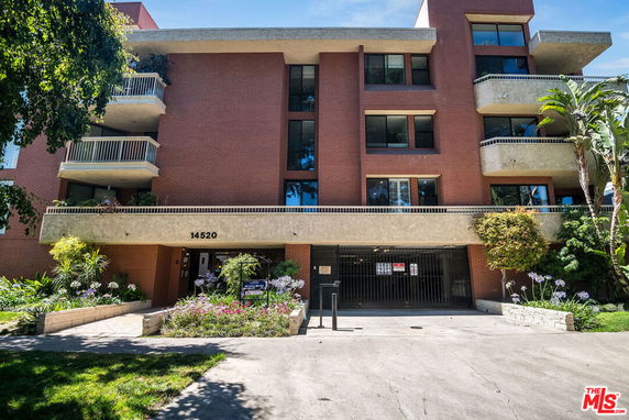 Front view of a multi-story brick building with balconies.