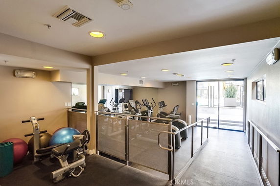 Indoor gym area with various exercise equipment including exercise bikes and stability balls.