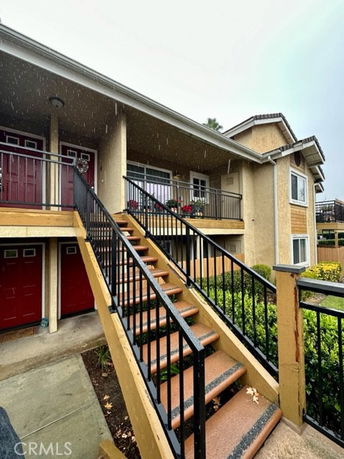 Front view of a two-story residential building with an external staircase.