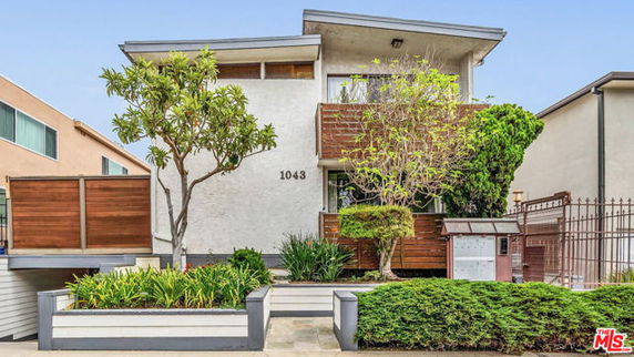 Front view of a two-story house with a modern design and wood accents, marked 1043.