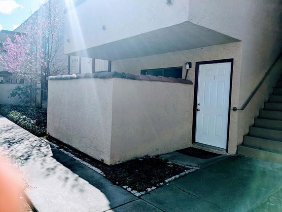 Front view of a house with stairs leading to the upper floor.