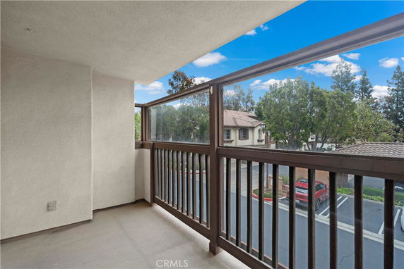 View from a balcony overlooking a residential area with parking spaces.