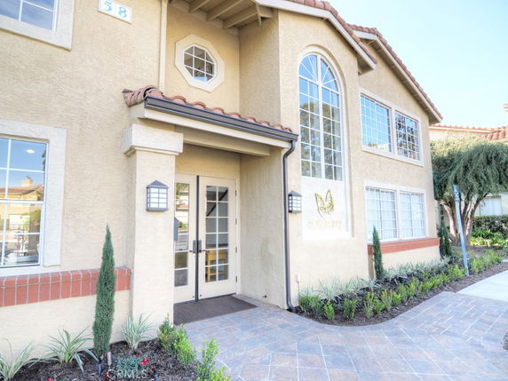 Front view of a two-story house with large arched windows.