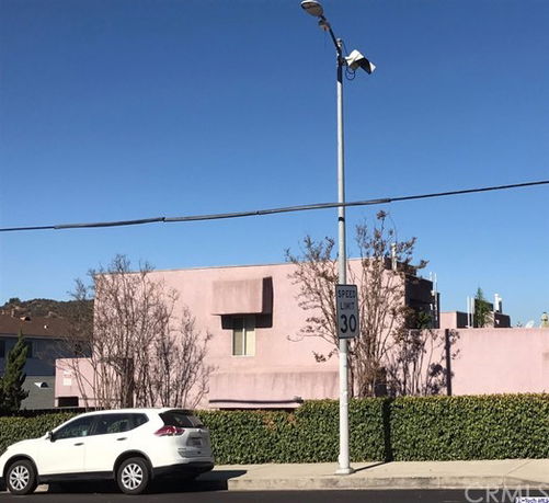 Front view of a pink multi-story building with a flat roof.