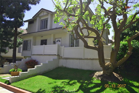 Front view of a two-story house with a balcony and white railing.
