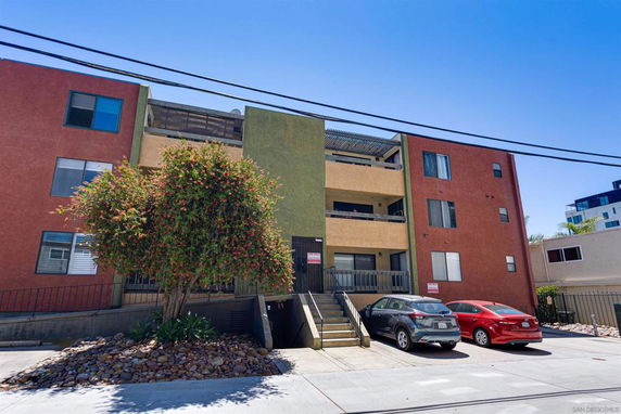 Front view of a multi-story apartment building with balconies.