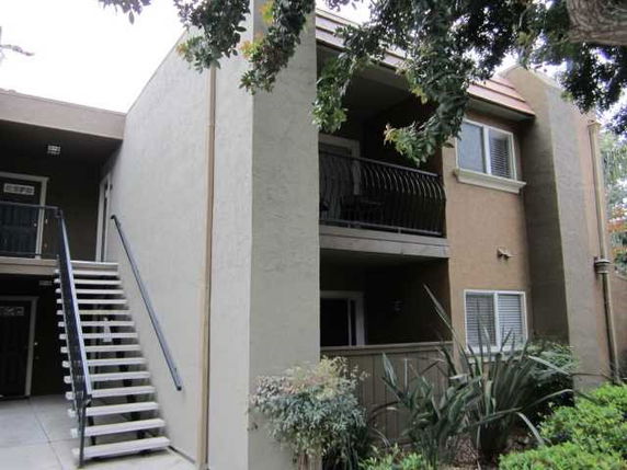 Front view of a two-story apartment building with exterior staircase.