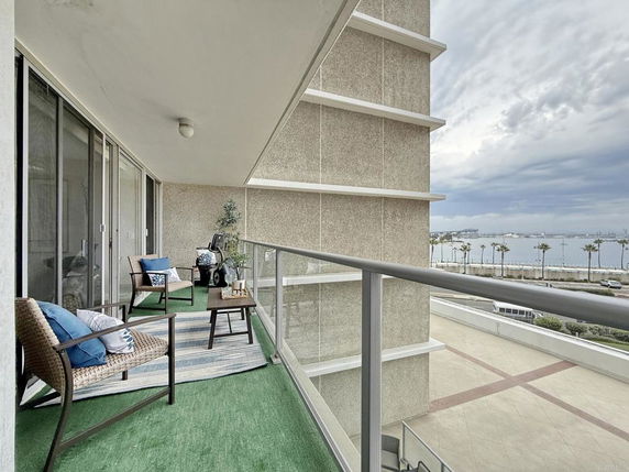 Balcony view overlooking a waterfront with distant cityscape.