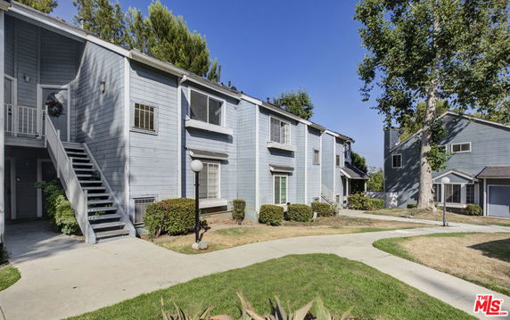 Front view of a two-story residential building with a staircase leading to the second floor.