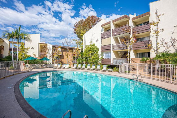 Outdoor view of a swimming pool surrounded by residential buildings.