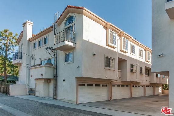 Front view of a multi-story residential building with multiple garages.