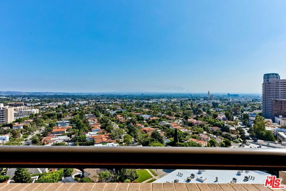 Panoramic view from a high vantage point overlooking a cityscape with buildings and greenery.