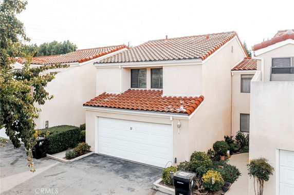 Front view of a two-story house with a white garage and red-tiled roof.