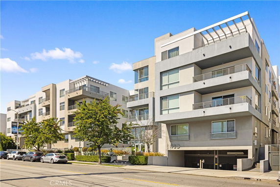 Front view of a modern multi-story apartment building with balconies.