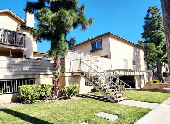 Front view of a multi-story building with exterior staircases and balconies.