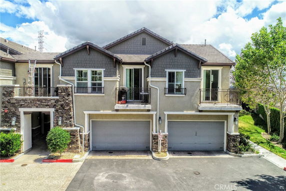Front view of a two-story house with double garages and stone accents.