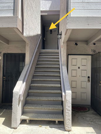 Entrance of a two-story building with stairs leading up to doors 409 and 410.