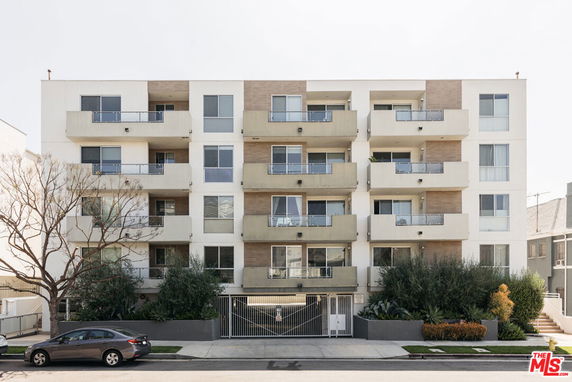 Front view of a multi-story apartment building with balconies.