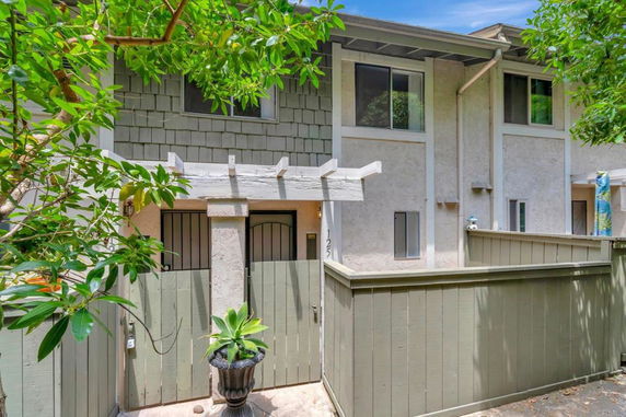 Front view of a two-story townhouse with a small fenced courtyard.