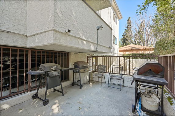 Outdoor patio area with barbecue grills and seating next to a building.
