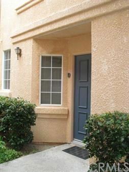 Front view of a house entrance with a blue door and cream walls.