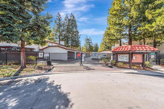 Front view of a gated residential complex entrance with buildings in the background.