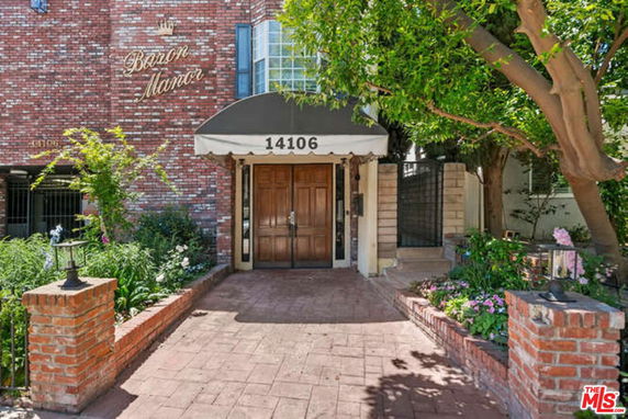 Front view of a brick building entrance with wooden doors and an awning labeled 'Baron Manor'.