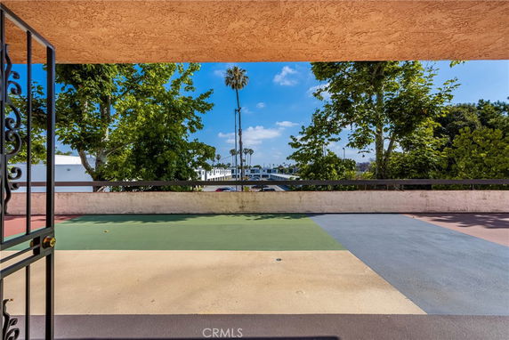 Wide-angle view from a terrace overlooking trees and distant buildings.