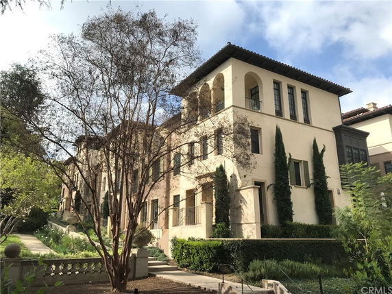 Front view of a multi-story residential building with a Mediterranean architectural style.