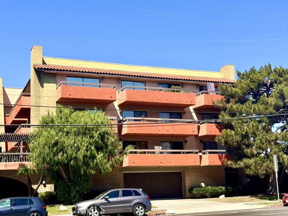 Front view of a multi-story residential building with multiple balconies.