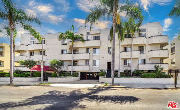 Front view of a multi-story residential building with balconies.