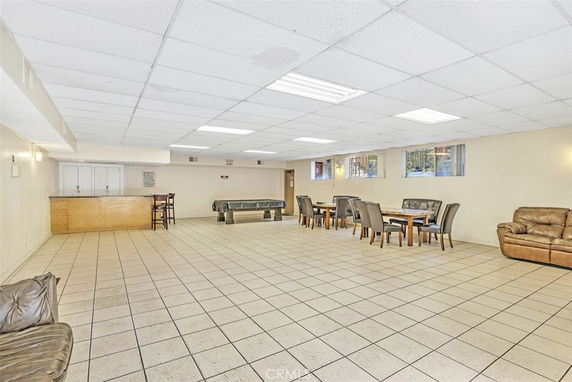 Spacious indoor recreation area with tables, chairs, and a bar counter.