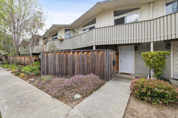 Front view of a two-story building with wooden fencing and a pathway leading to the entrance.