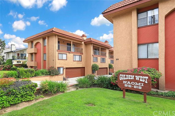 Front view of multi-story residential building with balconies and red roof tiles.