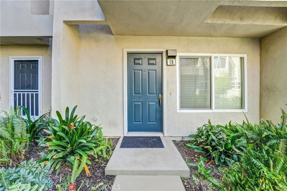 Front view of a house entrance with a blue door and a window beside it