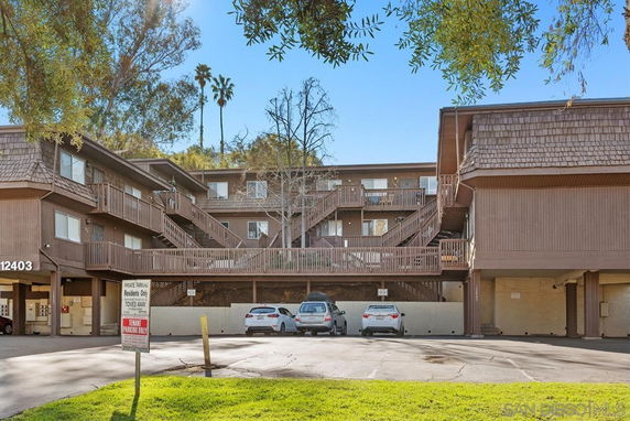 Front view of a multi-story apartment building with an open parking area.