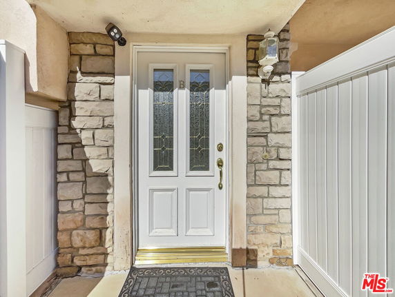 Front entrance of a house with a white door and stone trim.
