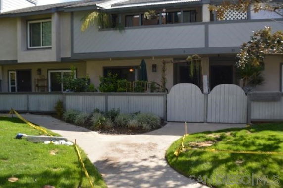 Front view of a two-story building with gated entrances and greenery.