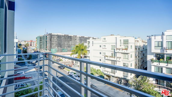 View from a balcony overlooking neighboring buildings and streets.