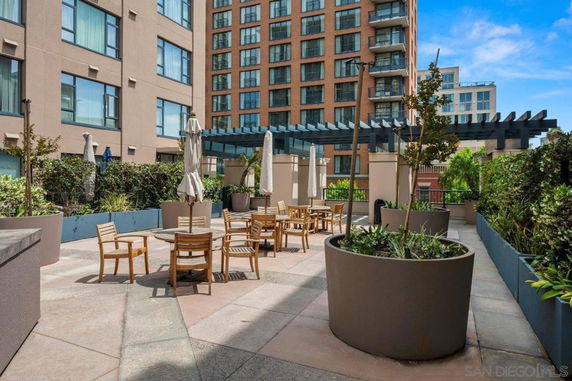 Rooftop area with outdoor seating and plants on a building.