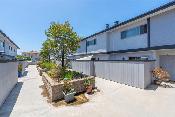 Front view of a townhouse with a small fenced patio.