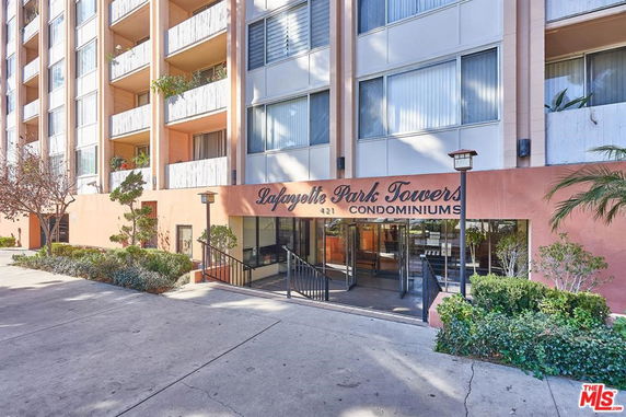 Front view of a multi-story condominium building with balconies.