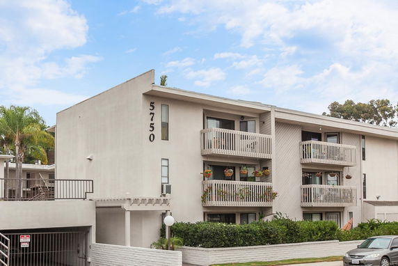 Front view of a multi-story apartment building with balconies.