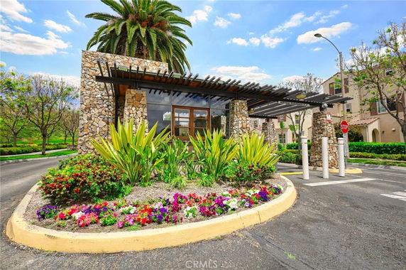 Front view of a small, stone-built guardhouse with a pergola-style roof at an entrance.