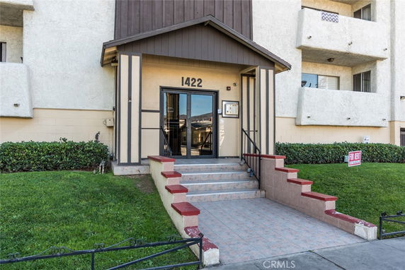 Front view of a residential building entrance with steps leading up to the door.