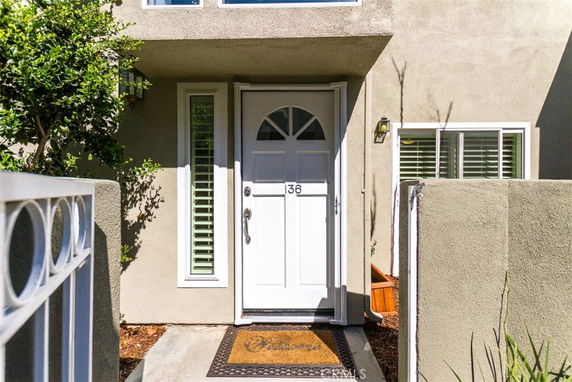 Front view of a house entrance with a white door and windows.