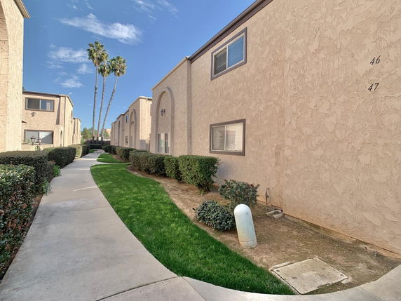 Front view of a two-story building with stucco walls and multiple windows.
