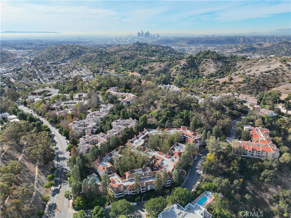 Panoramic view of a residential area with hills and cityscape in the background.