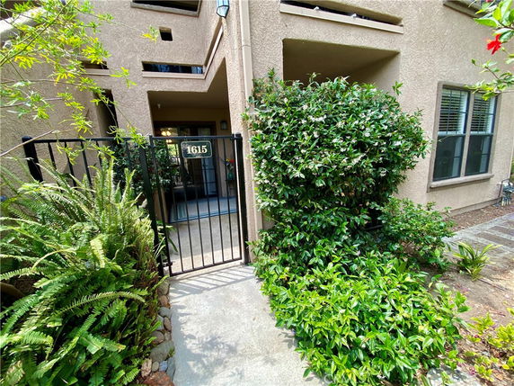 Entrance view of a residential building with gate and plants.