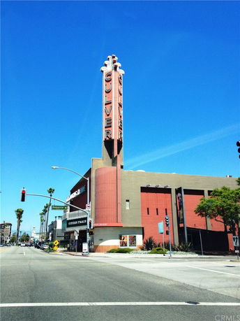 Front view of a building with a tall sign tower and multiple structures.